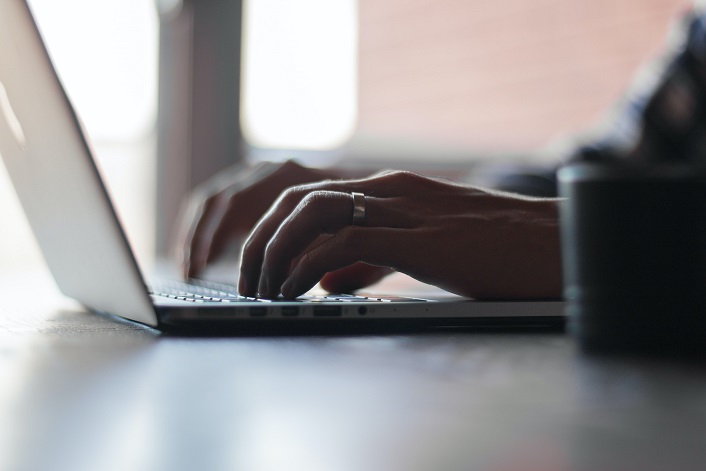 hands typing on laptop