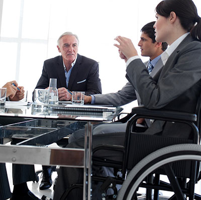 woman in wheelchair speaking in an office meeting