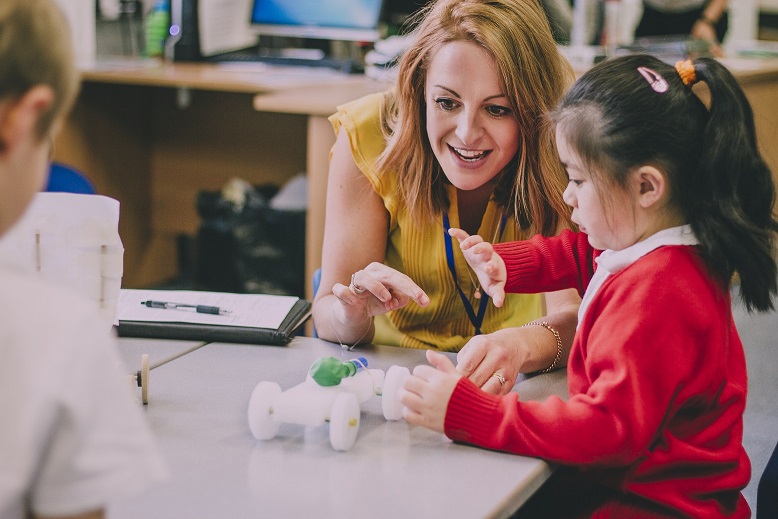 teacher working with student at a desk